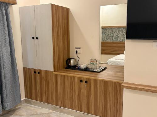 Habitación con encimera de madera y espejo. en Vainavi Residency, en Tirupati