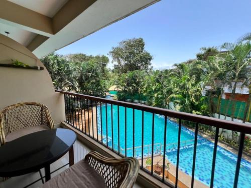 a balcony with a view of a swimming pool at Ashvem Beach inn in Mandrem