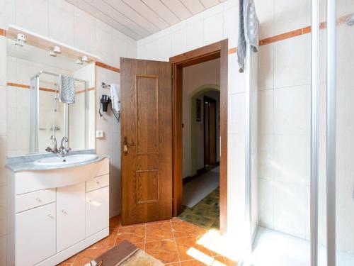 a bathroom with a sink and a wooden door at Farmhouse in Itter near Ski Slopes in Itter