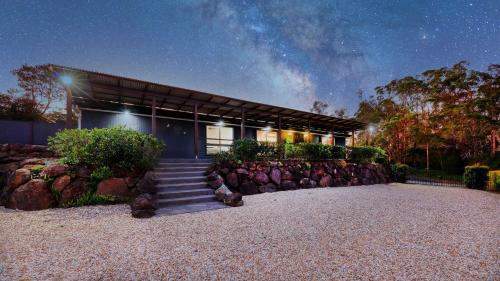a house with a staircase in front of it at night at Honey Badgers House in Mount Tamborine