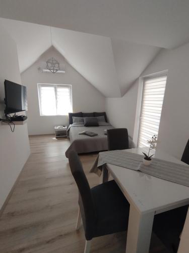 a bedroom with a bed and a table and a couch at Oaza apartman in Soko Banja