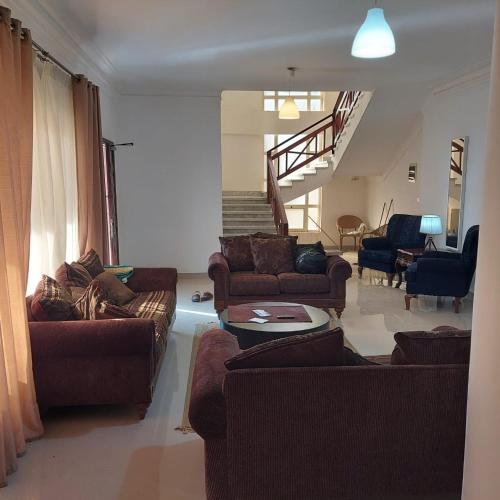 a living room with couches and a staircase at El dakroury king mariout villa in Naj‘ al Aḩwāl