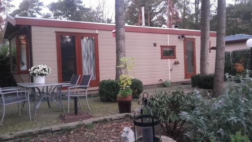 a small pink cabin with a table and chairs at Jachtslot Chalet J8 in Doornspijk