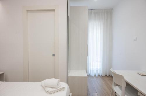 a white room with a bed and a mirror at Bed and Breakfast Al Portanova in Reggio Calabria