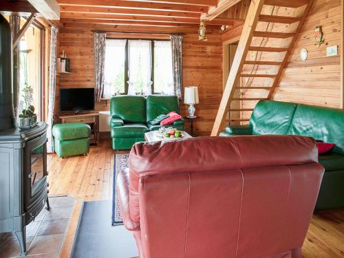 a living room with a red couch and green chairs at Peaceful Retreat with Sauna in Fraiture