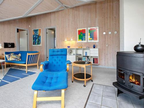 a living room with a blue chair and a stove at 4 star holiday home in Henne in Henne Strand