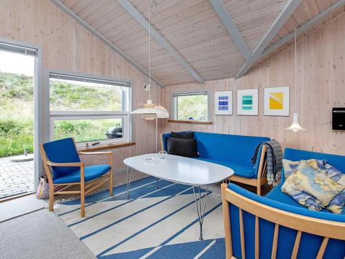 a living room with blue chairs and a table at 4 star holiday home in Henne in Henne Strand