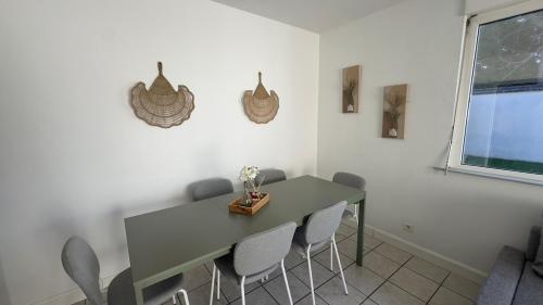 a dining room with a green table and chairs at Maison familiale près de Disney in Lagny