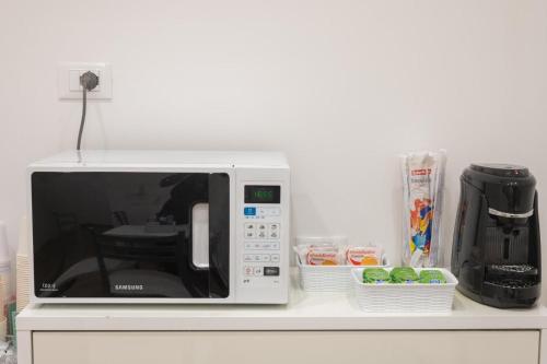 a white microwave sitting on a counter with food at Bed and Breakfast Al Portanova in Reggio Calabria