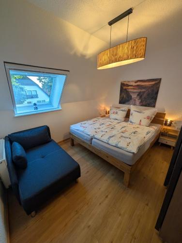 a bedroom with a bed and a chair and a window at Haus Erika in Prerow