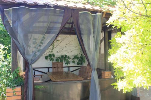 a gazebo with a table and a curtain at Villa Diana Mini in Karolino-Buhaz