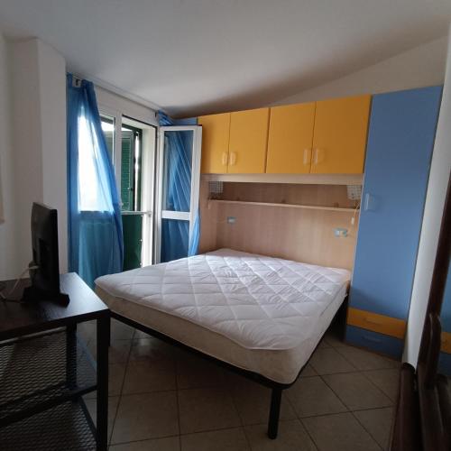 a small bedroom with a bed and yellow cabinets at Estensi 14 in Lido degli Estensi