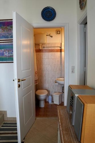 a small bathroom with a toilet and a sink at View & Chill Syros in Vári