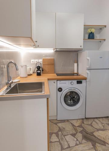 a kitchen with a sink and a washing machine at Kalamis Seaview2 in Samos