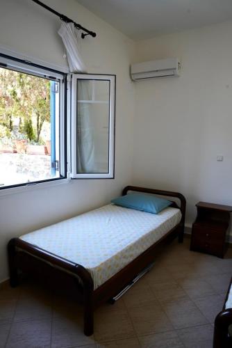 a bed in a room with a window at View & Chill Syros in Vari
