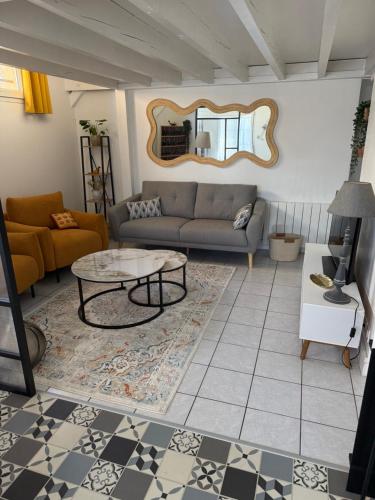 a living room with a couch and a table at Maison aux portes de la Sologne in Marcilly-en-Villette