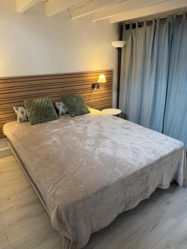 a bedroom with a large bed with blue curtains at Maison aux portes de la Sologne in Marcilly-en-Villette