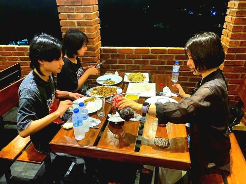 a group of people sitting around a table eating food at Airport 4 Season Transit Hotel in Katunayake