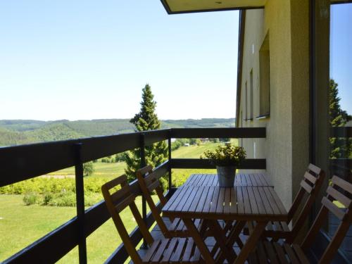a wooden table on a balcony with two chairs at Family Apartment Bouillon and Semois River in Gros-Fays