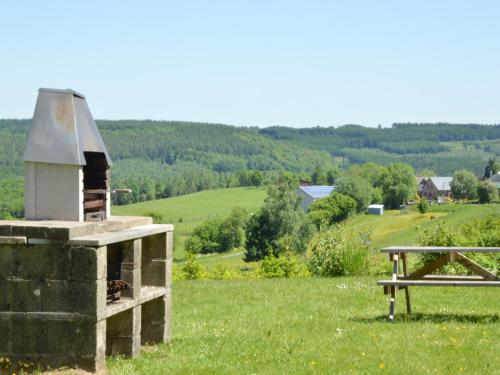 a picnic table and a building in a field at Family Apartment Bouillon and Semois River in Gros-Fays