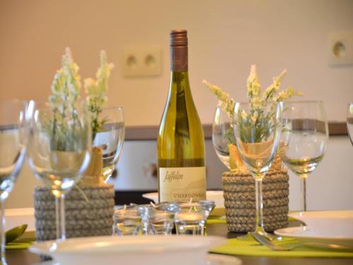 a bottle of wine sitting on a table with glasses at Family Apartment Bouillon and Semois River in Gros-Fays