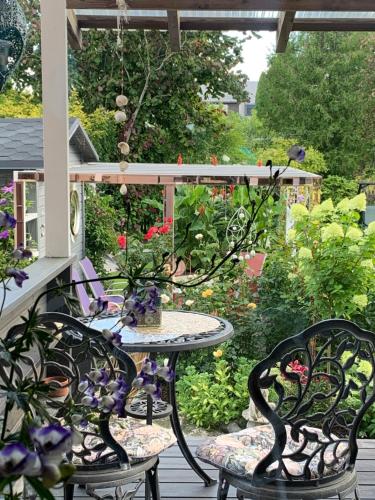 a table and chairs on a porch with a garden at Villa Mariett in Kuressaare