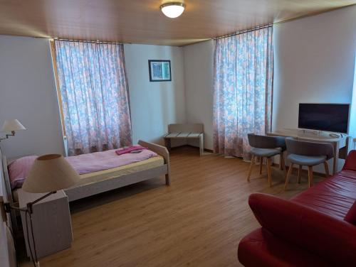 a bedroom with a bed and a desk and a tv at Gasthof zur alten Post in Büren an der Aare