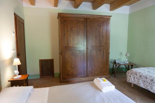 a bedroom with a large wooden cabinet next to a bed at Re Artù Assisi Country Lifestyle in Assisi