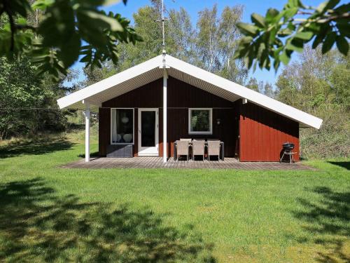 a red and black building with a table and chairs at 4 person holiday home in Læsø-By Traum in Læsø