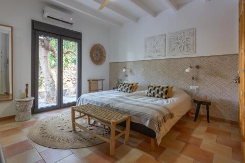 a bedroom with a bed with a bench in it at Bed & Breakfast Casa del Palta in Canillas de Albaida