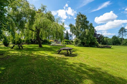 a picnic table in a park with a tree at Northop Hall Country House Hotel in Mold