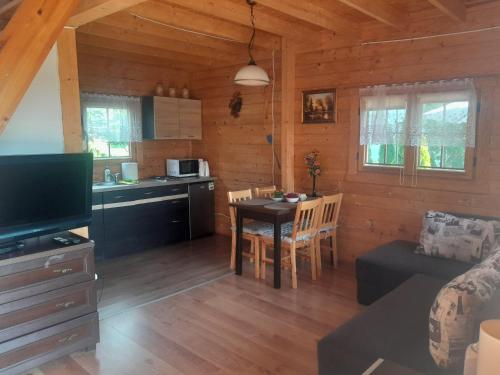 a kitchen and living room with a table and a couch at Agroturystyka u Krystyny in Rybczewice