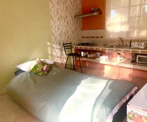 a kitchen with a bed in the corner of a room at Quinta YaaxBe in Homún