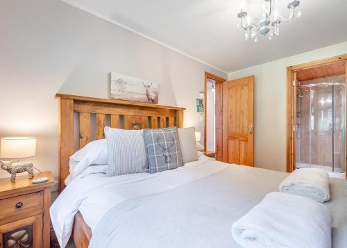 a bedroom with a large bed with a wooden headboard at Charlesworth Lodges in Glossop