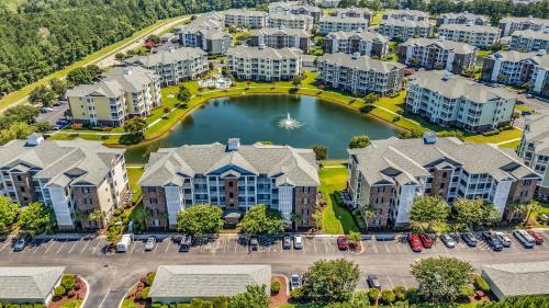 an aerial view of a apartment complex with a pond at Myrtlewood by Monarch Rentals in Myrtle Beach