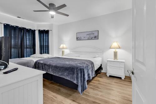 a bedroom with two beds and a ceiling fan at Myrtlewood by Monarch Rentals in Myrtle Beach