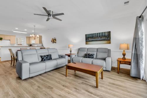 a living room with two couches and a table at Myrtlewood by Monarch Rentals in Myrtle Beach