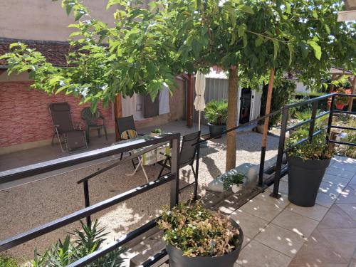 a balcony with trees and a table and chairs at Chambre d'hôtes Juline in Pouilly-les-Nonains