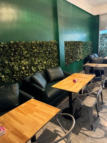 ein Restaurant mit Tischen und einer grünen Wand in der Unterkunft Green Terrace Residence Phuket in Kathu