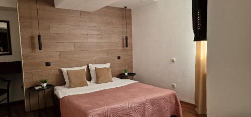 a bedroom with a large bed with a wooden headboard at Pensiunea Studio in Bacău