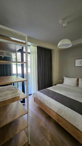 a bedroom with a large bed and a large window at Arkhi Kokhta Bakuriani Apt 304 in Bakuriani