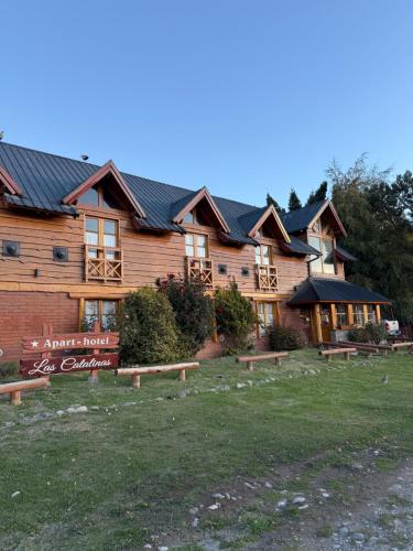 a log cabin with benches in front of it at Las Catalinas in San Martín de los Andes