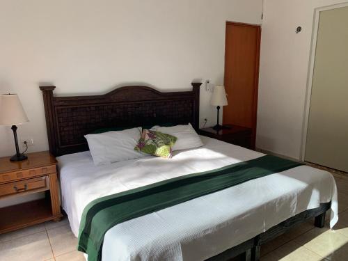 a bedroom with a large bed with a wooden headboard at Quinta YaaxBe in Homún