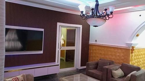 a living room with a couch and a television at A Luxury 3 bedroom bungalow in Owerri
