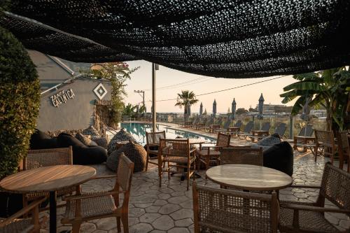 a patio with tables and chairs and a pool at Zante Calinica Hotel in Tsilivi