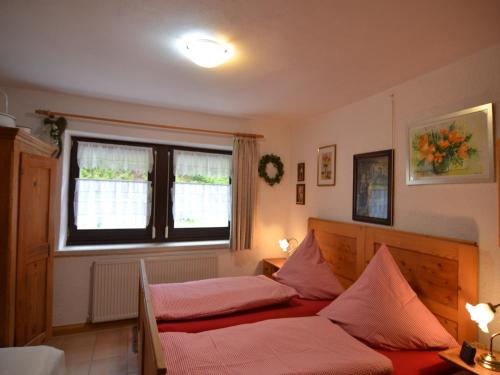a bedroom with a bed with pink sheets and a window at Ferienhaus in Saldenburg mit Sauna in Saldenburg