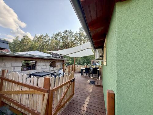 a wooden deck with a fence and tables and chairs at Ferienhaus am See in Staupitz