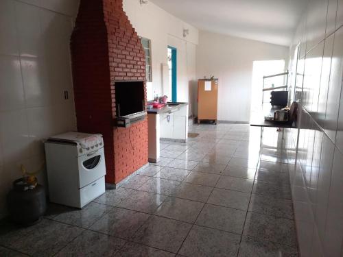 a kitchen with a stove and a brick wall at Pousada Roosevelt- suíte 1 in Uberlândia