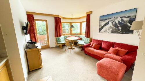 a living room with a red couch and a table at Ferienwohnung Königsleiten 77 - Top 9 in Königsleiten