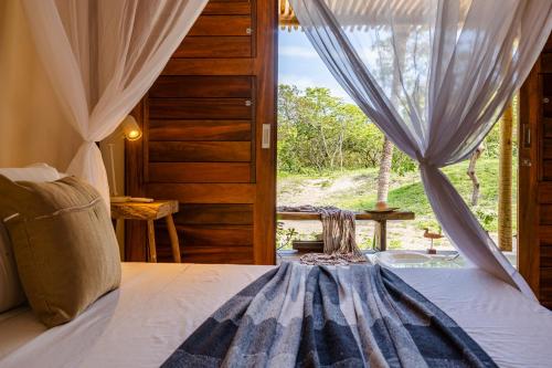 a bedroom with a bed and a large window at Casa Yemanjá in Acaraú